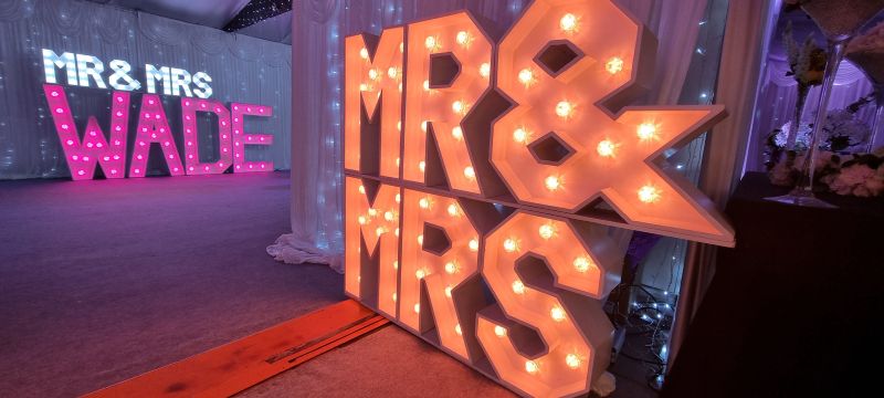 Small MR & MRS letters above an illuminated surname
